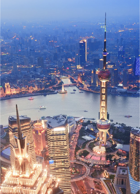 Aerial view of Shanghai's skyline at dusk, featuring the illuminated Oriental Pearl Tower and surrounding skyscrapers.